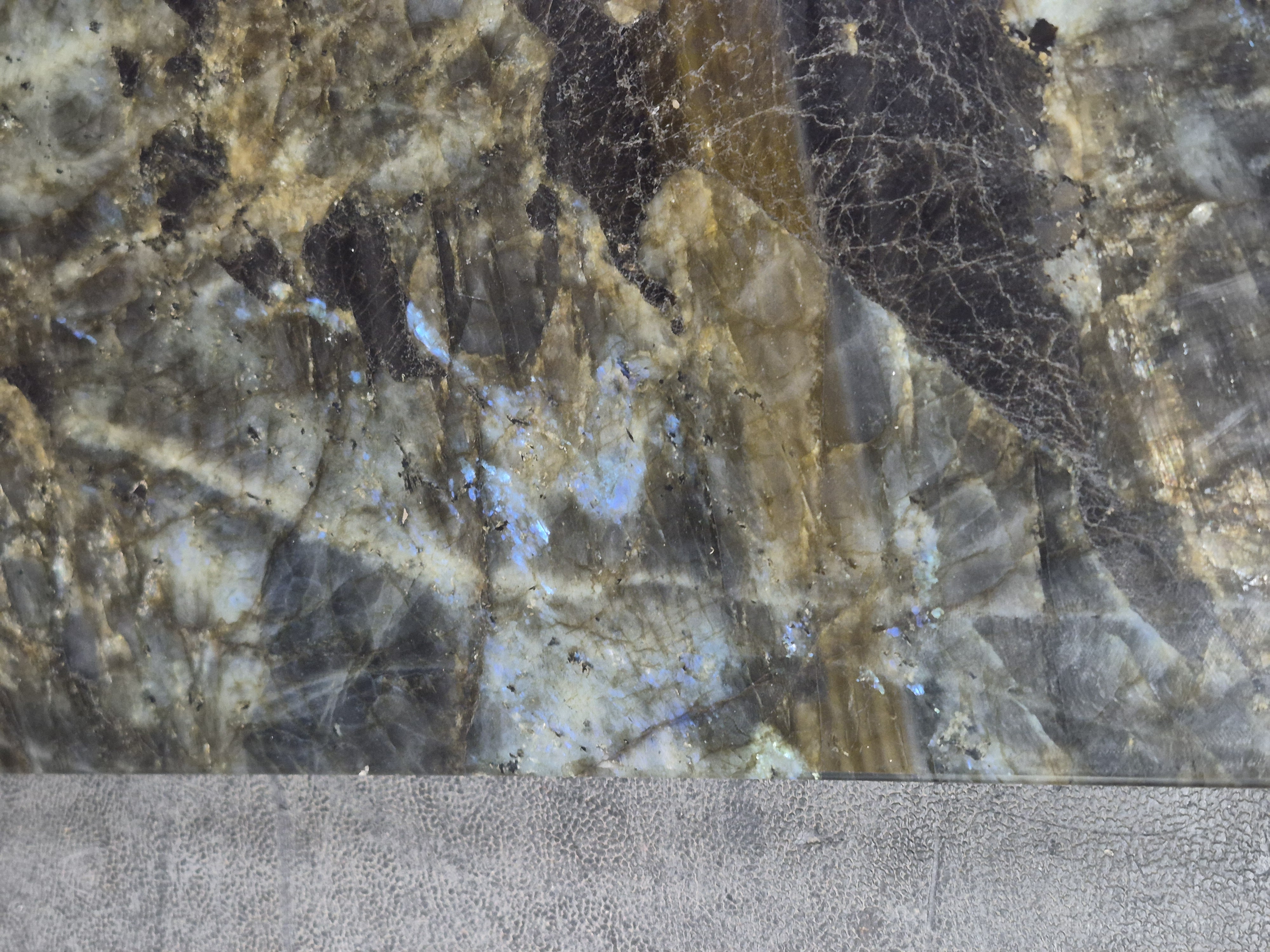 A fractured labradorite slab with flashes across it