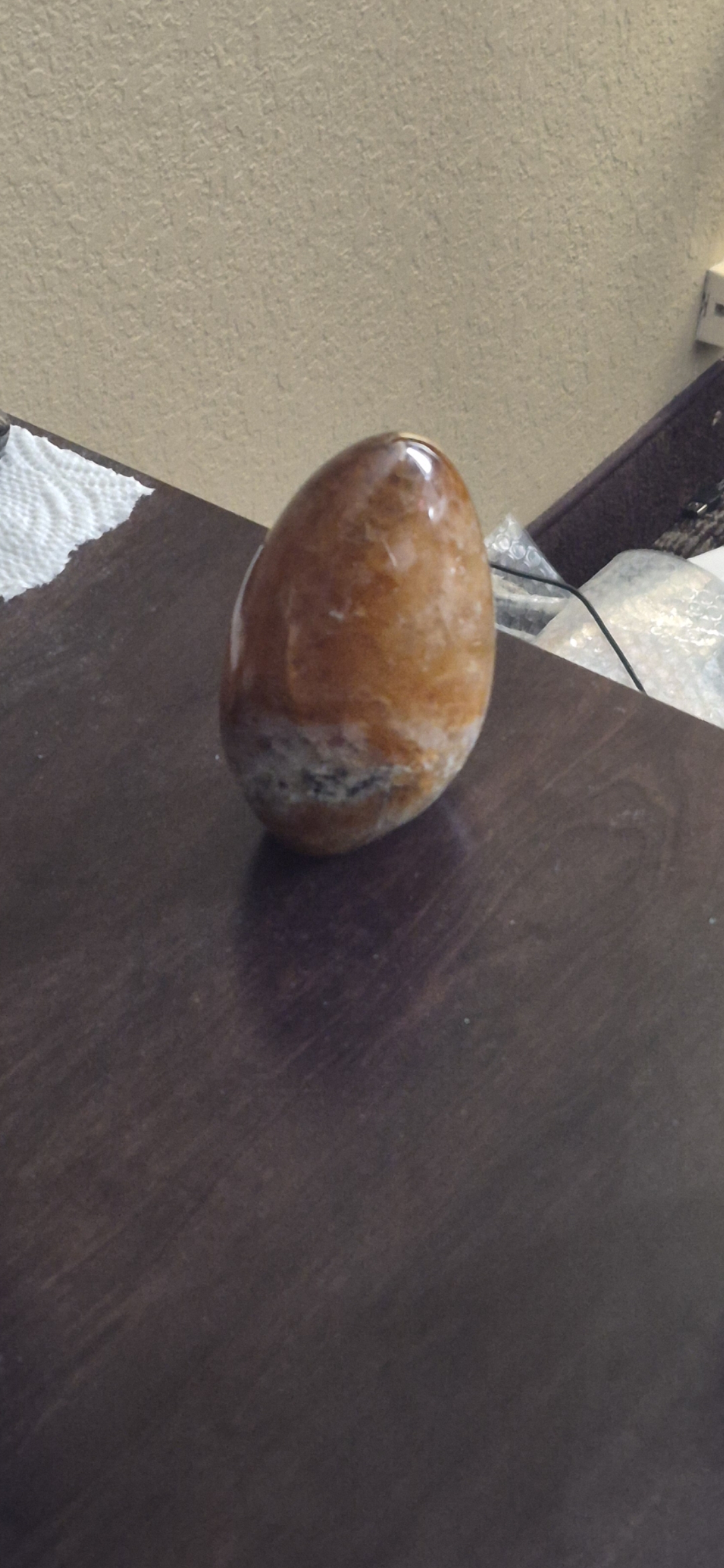 A polished egg shaped specimen, light brown with marbling