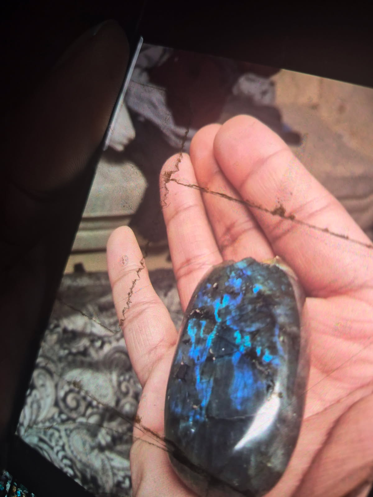 The labradorite in the hand, the flash broken into patches