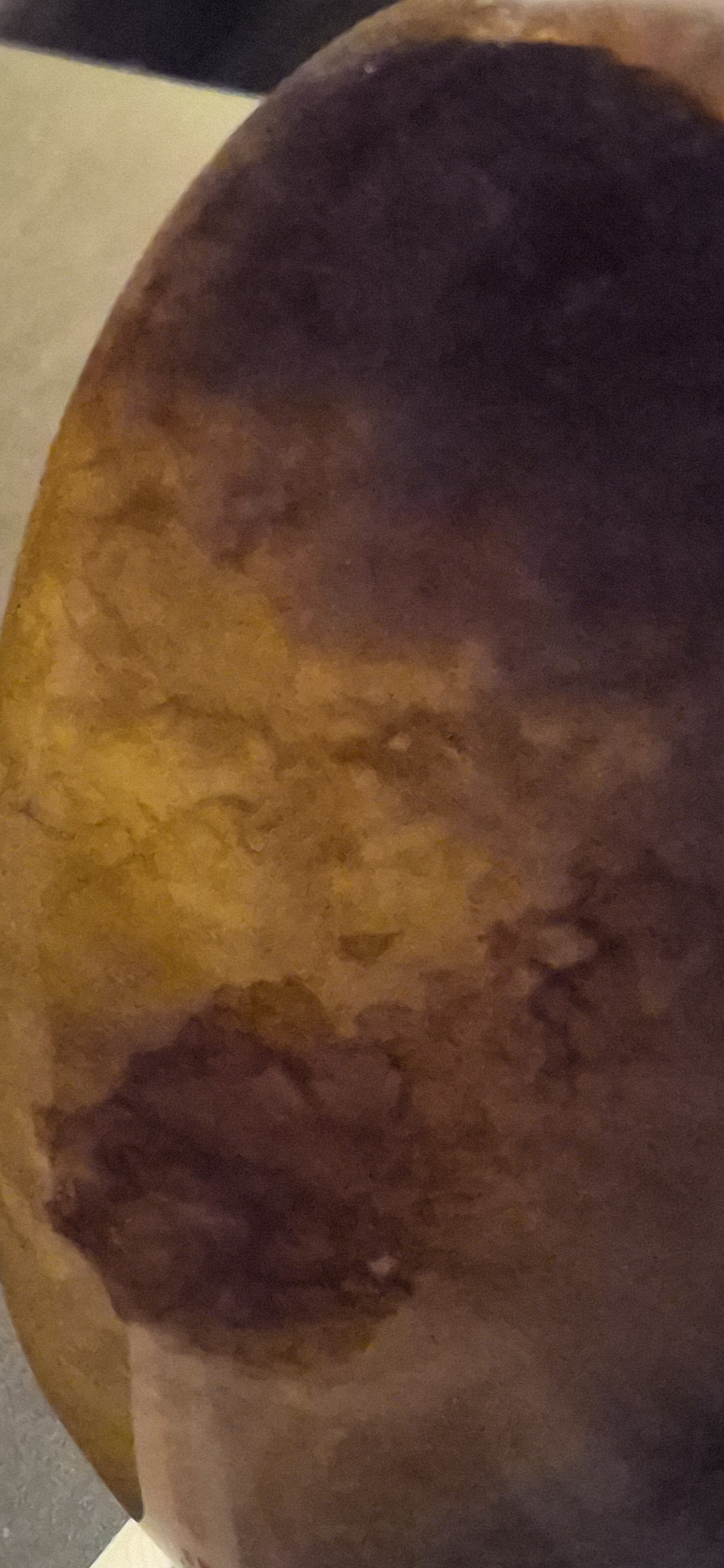 A curved surface, yellow tan to dark brown