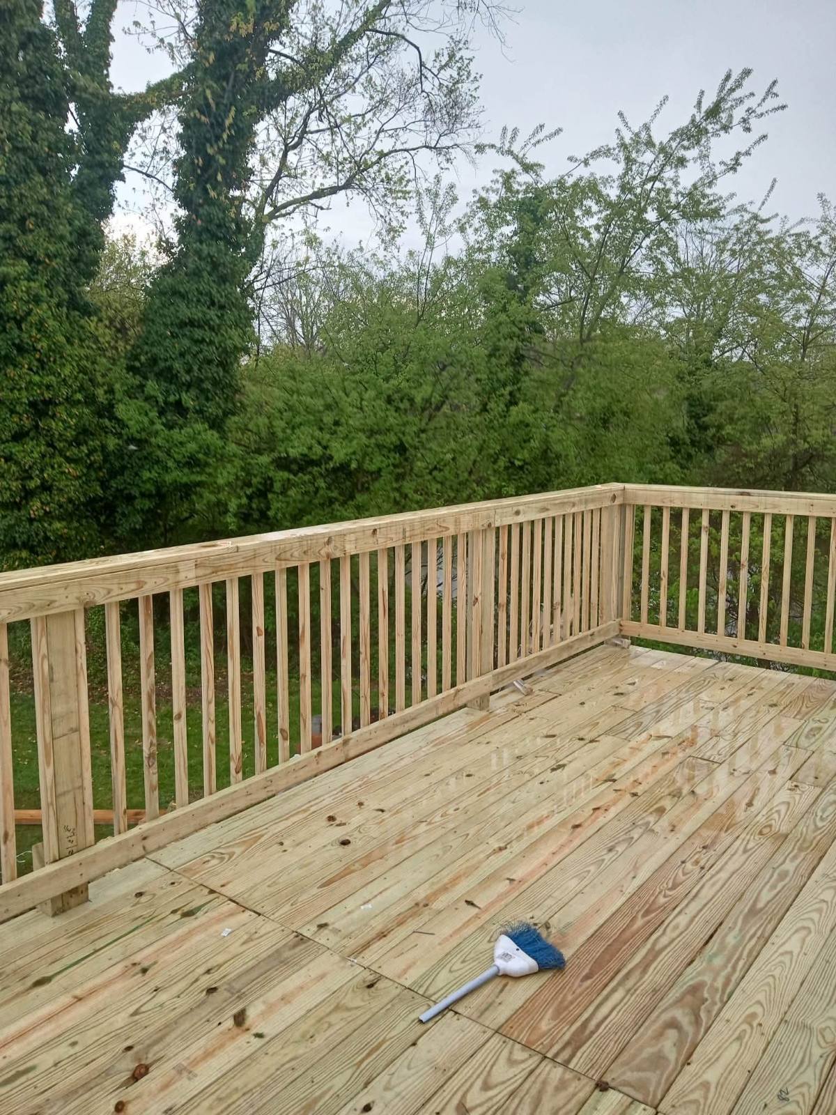 Finished pressure-treated deck against a tree line